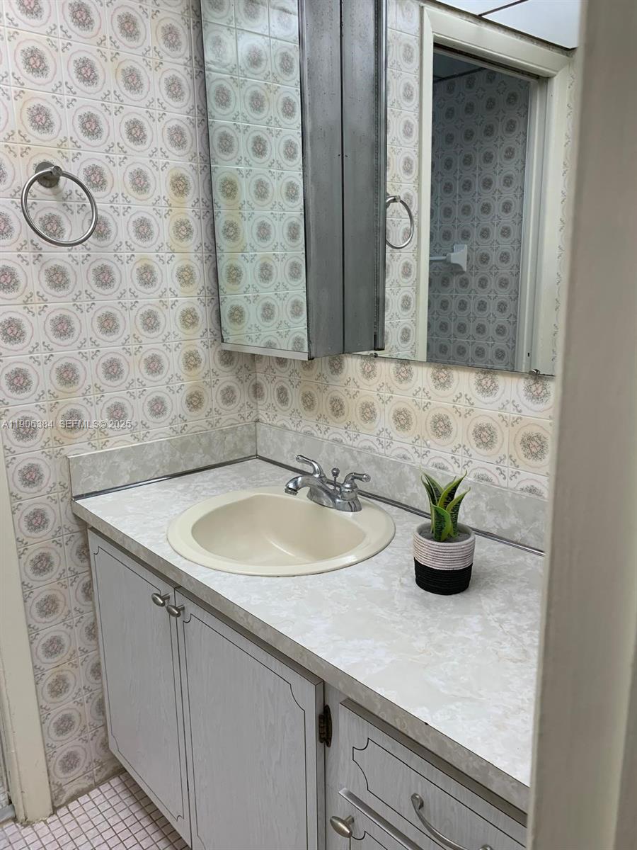 2690 Southwest 22nd Avenue, Unit 505 Miami, FL 33133 - Photo 20 of 21 a bathroom with a sink a mirror and a potted plant