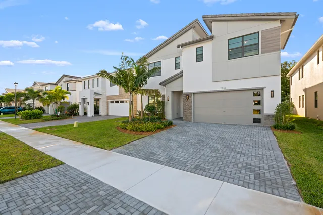 a view of a white house with a yard and large tree