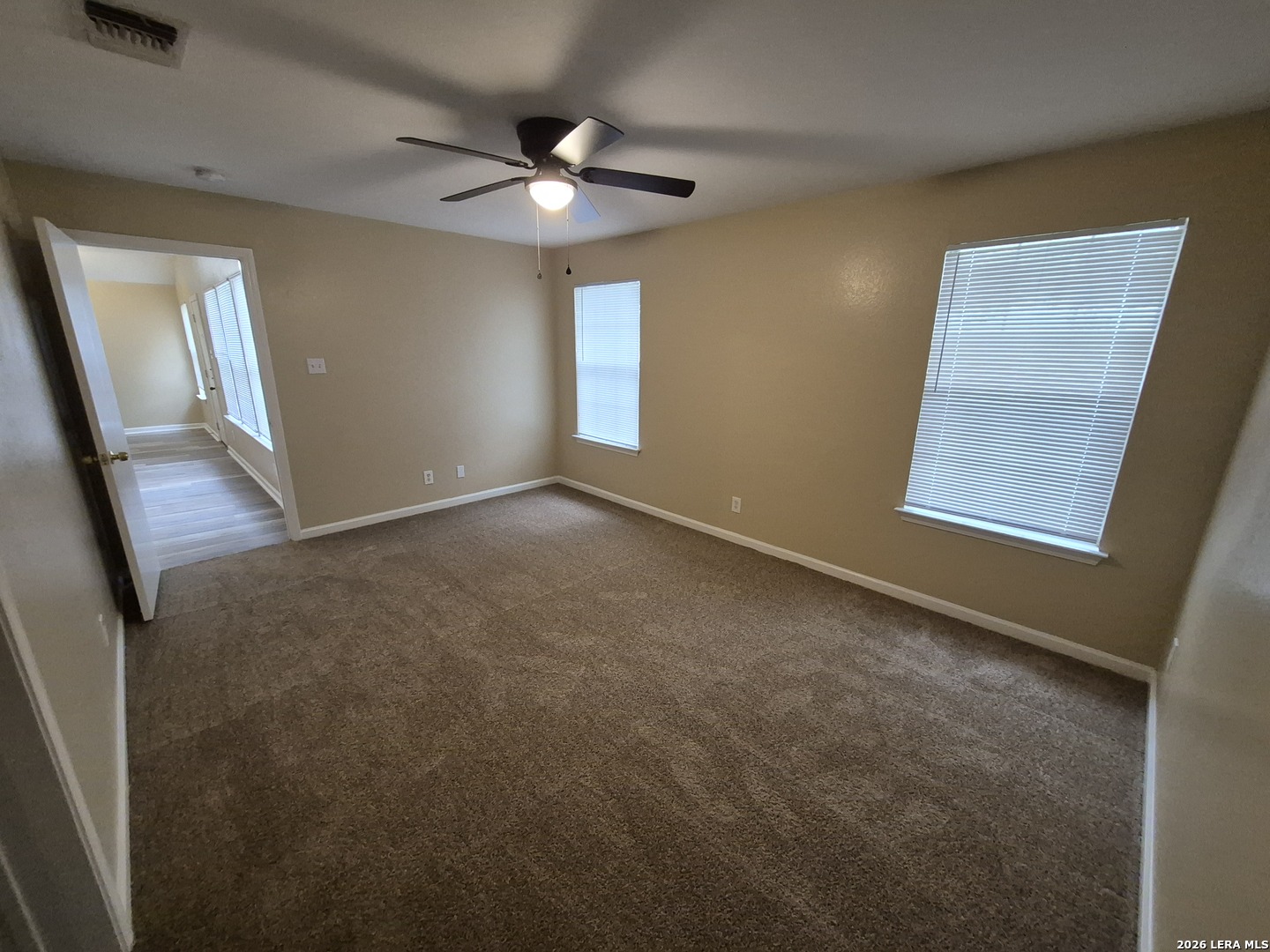 8806 Slumber Lane Converse, TX 78109 - Photo 25 of 39 an empty room with windows and fan