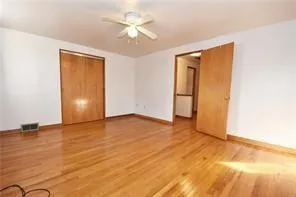 an empty room with wooden floor and closet area
