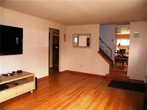a view of a livingroom with wooden floor and a flat screen tv