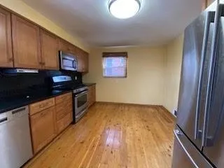 a kitchen with granite countertop wooden cabinets and a stove top oven
