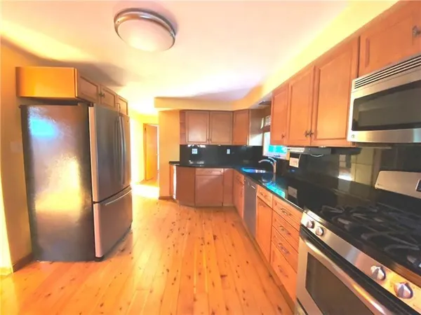 a kitchen with stainless steel appliances granite countertop a refrigerator a stove a sink and a microwave