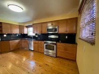 a kitchen with granite countertop a sink and cabinets
