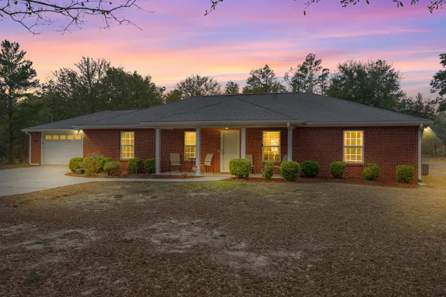 a front view of a house with yard patio and garden