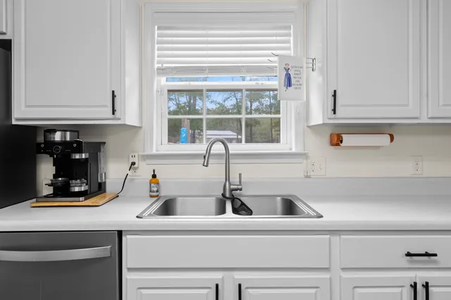 a kitchen with white cabinets and refrigerator