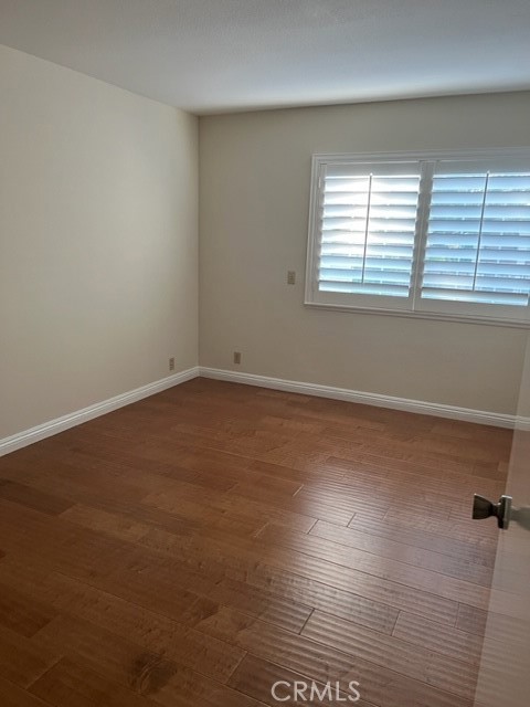 19616 Georgina Circle Cerritos, CA 90703 - Photo 12 of 16 an empty room with wooden floor and windows