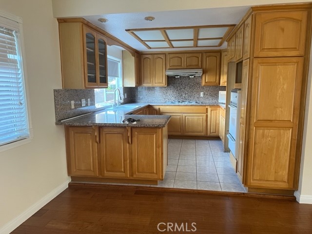 19616 Georgina Circle Cerritos, CA 90703 - Photo 2 of 16 a kitchen with stainless steel appliances granite countertop a refrigerator a stove and a wooden cabinets