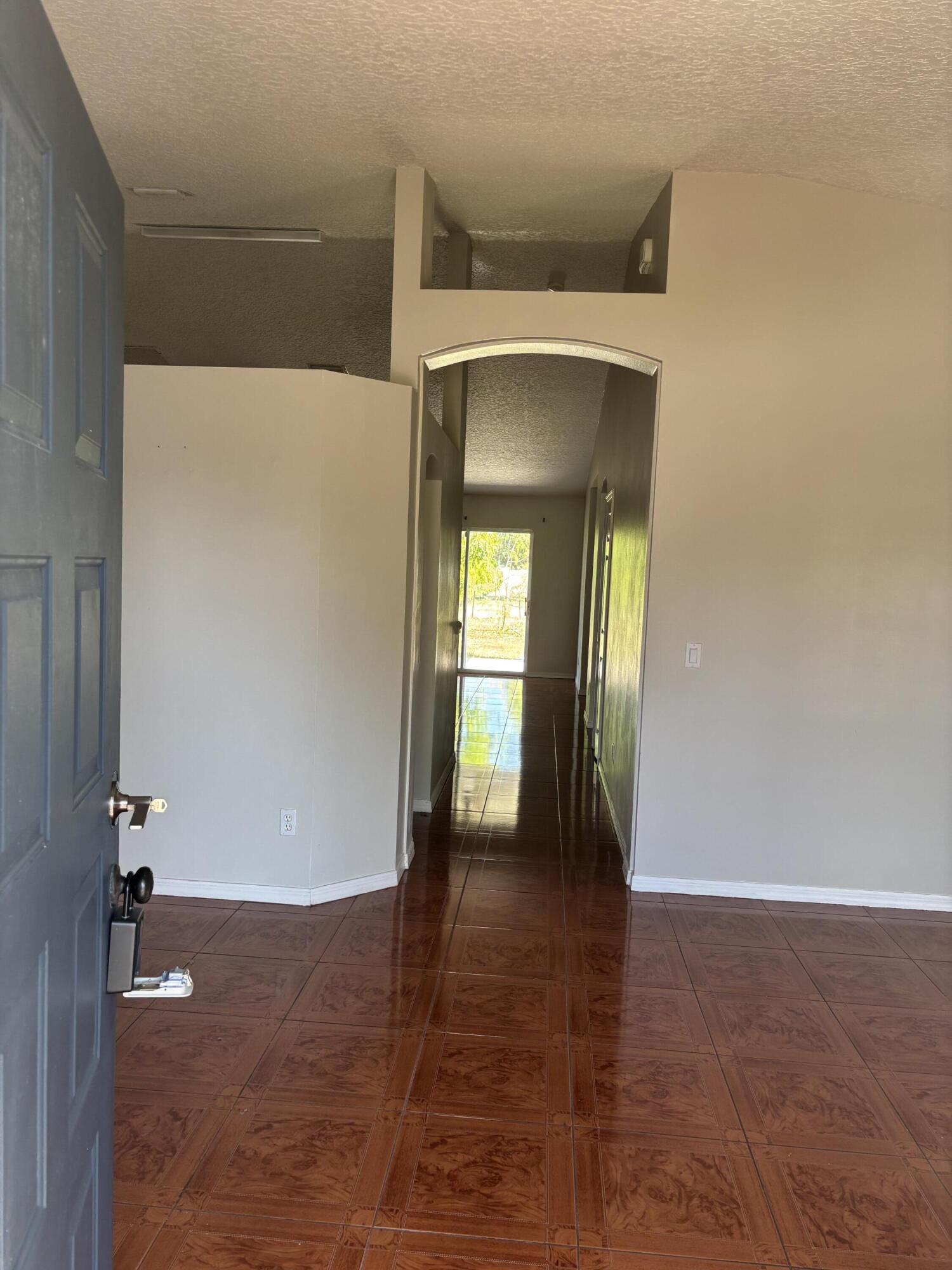 4397 Southwest Calah Circle Port St. Lucie, FL 34953 - Photo 2 of 10 a view of a hallway with wooden floor and a bathroom