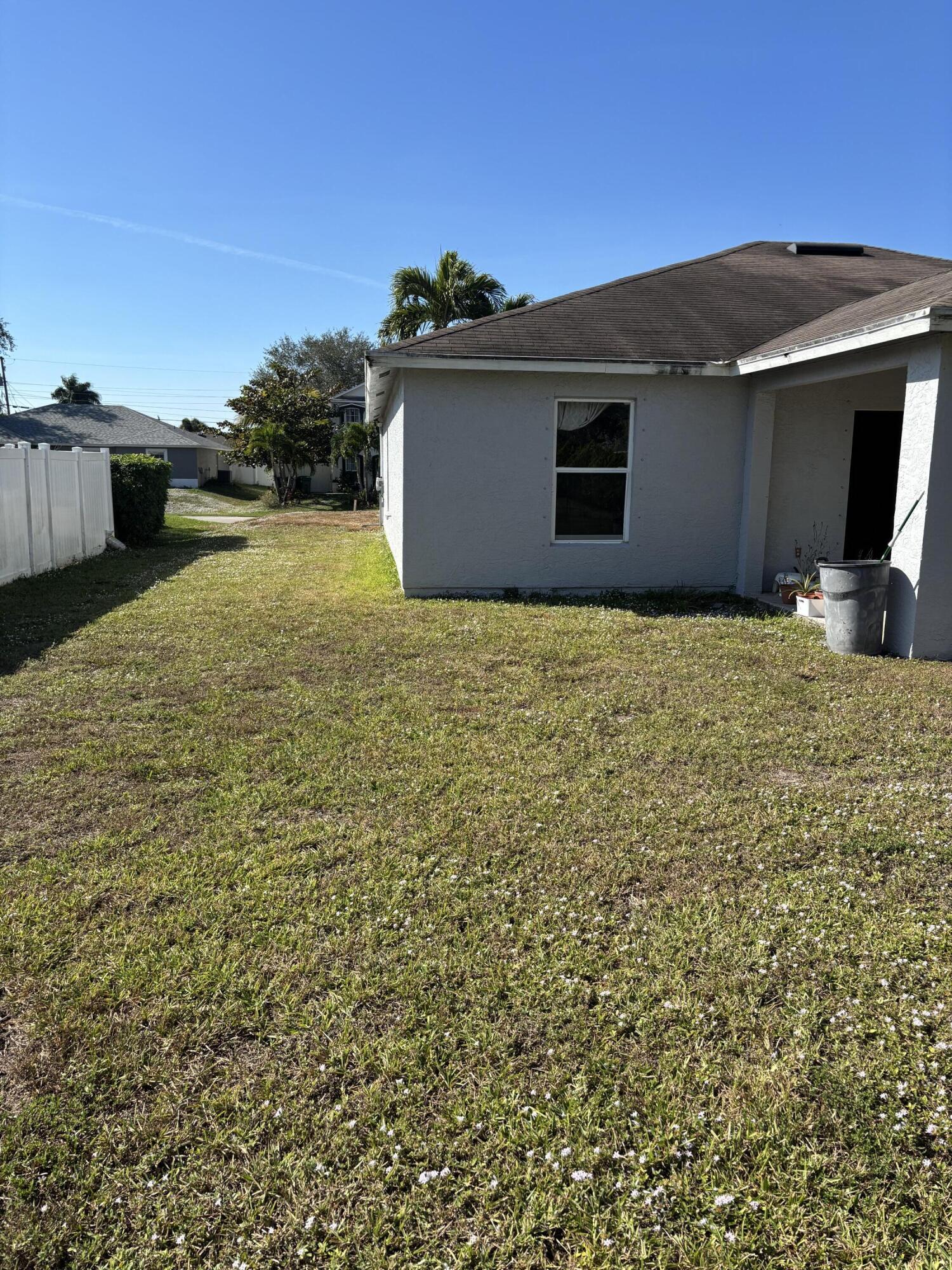 4397 Southwest Calah Circle Port St. Lucie, FL 34953 - Photo 9 of 10 a backyard of a house with a yard
