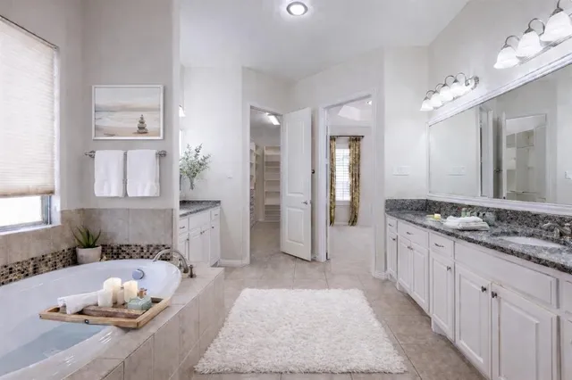 a spacious bedroom with a bed and a chandelier