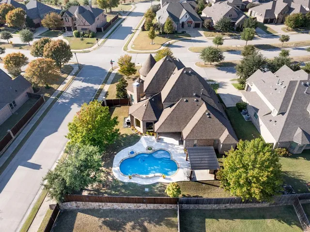 an aerial view of a house with a yard and large trees