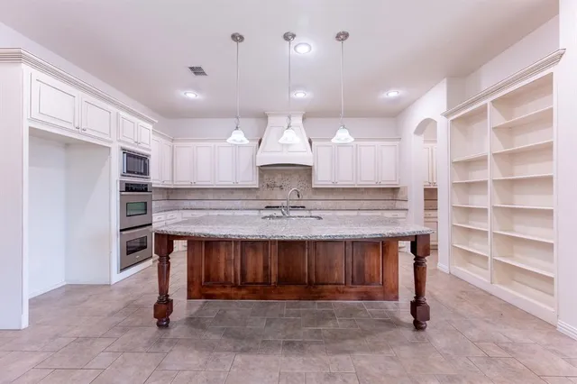a view of kitchen with kitchen island a sink stainless steel appliances and cabinets