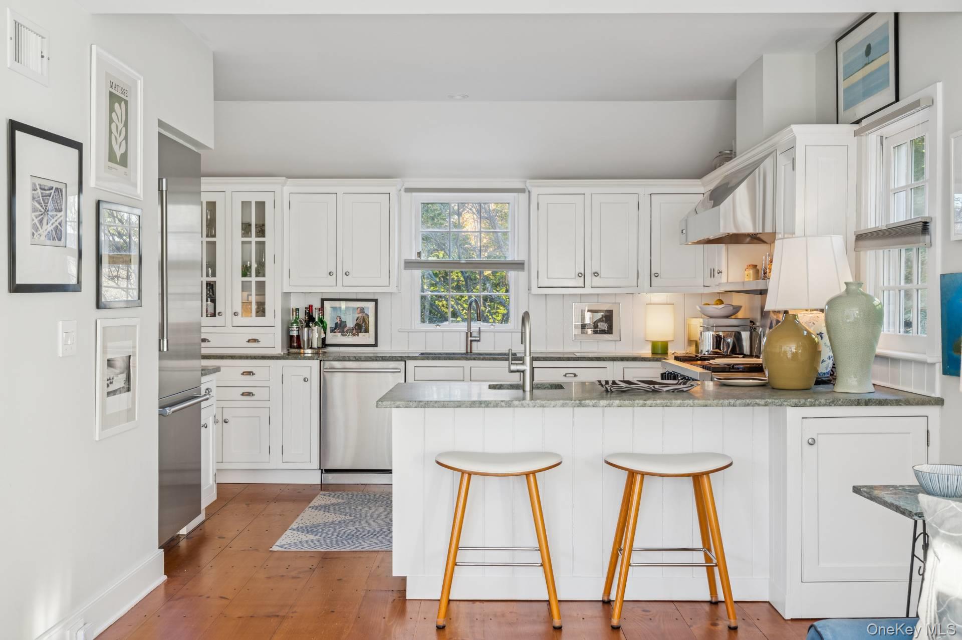 94 Post Lane Southampton, NY 11968 - Photo 20 of 34 a kitchen with stainless steel appliances granite countertop a stove top oven a sink and cabinets