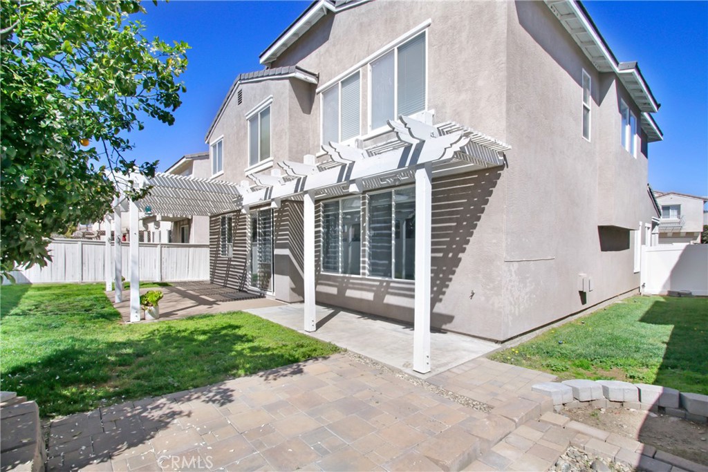 32509 Sunnyvail Circle Temecula, CA 92592 - Photo 31 of 38 a view of a white house with a yard and table and chairs under an umbrella