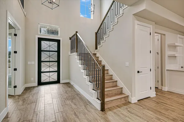 a view of a hallway with wooden floor and staircase