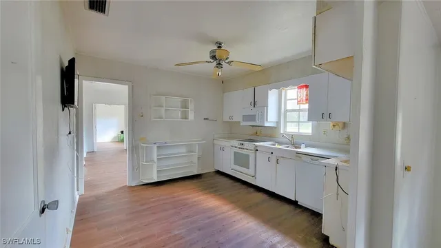 a kitchen with a white cabinets and wooden floor