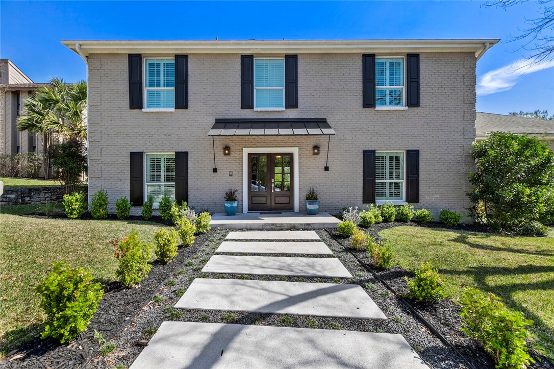a front view of a house with a garden