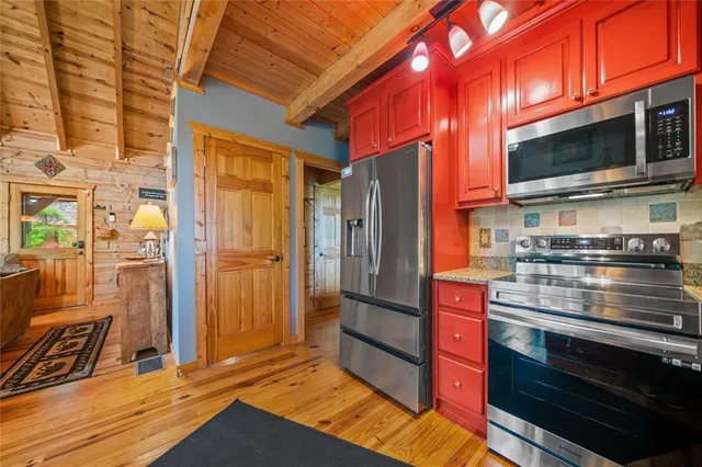a kitchen with stainless steel appliances granite countertop a refrigerator and a stove