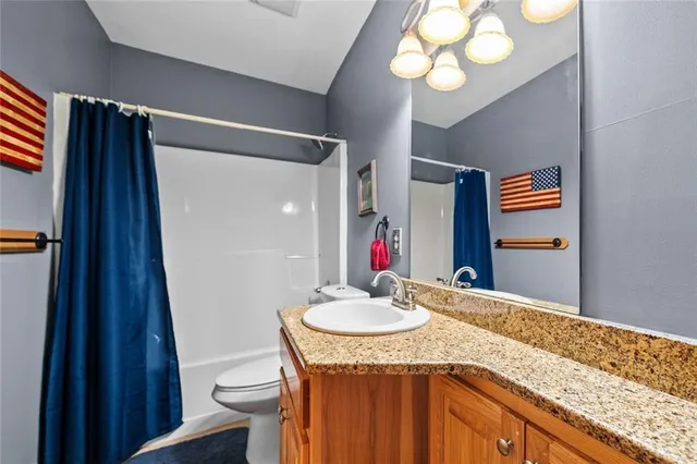 a bathroom with a granite countertop sink a mirror and vanity