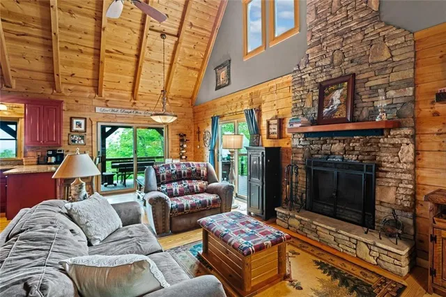 a living room with furniture a fireplace and a floor to ceiling window