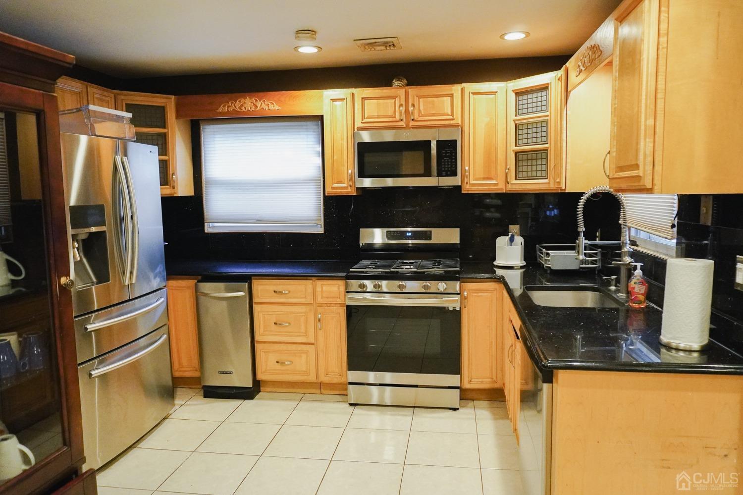 140 Meredith Road Colonia, NJ 07067 - Photo 7 of 30 a kitchen with stainless steel appliances granite countertop a stove a sink and a microwave