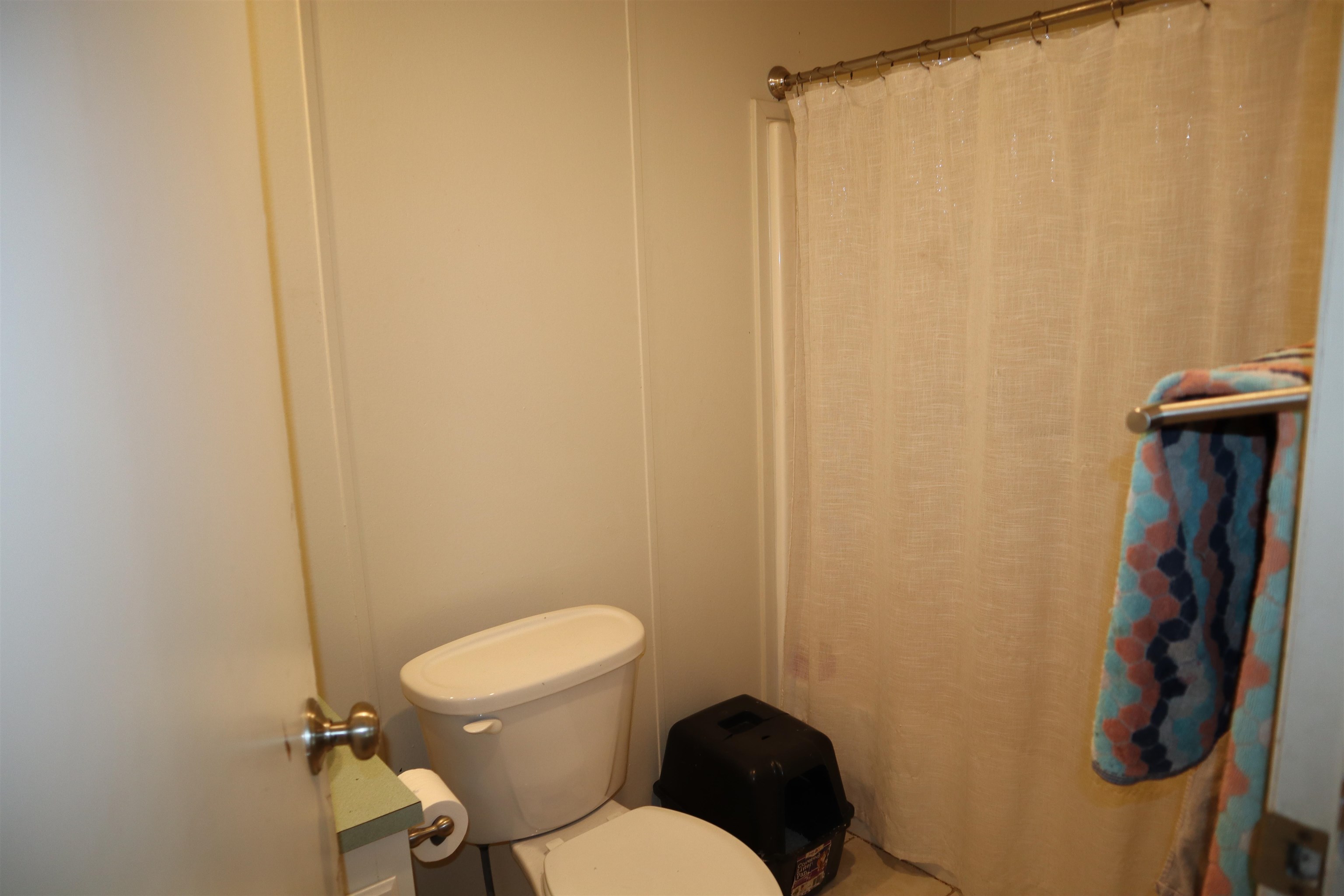 193 Fairground Road Quincy, CA 95971 - Photo 12 of 20 a white toilet sitting next to a shower curtain