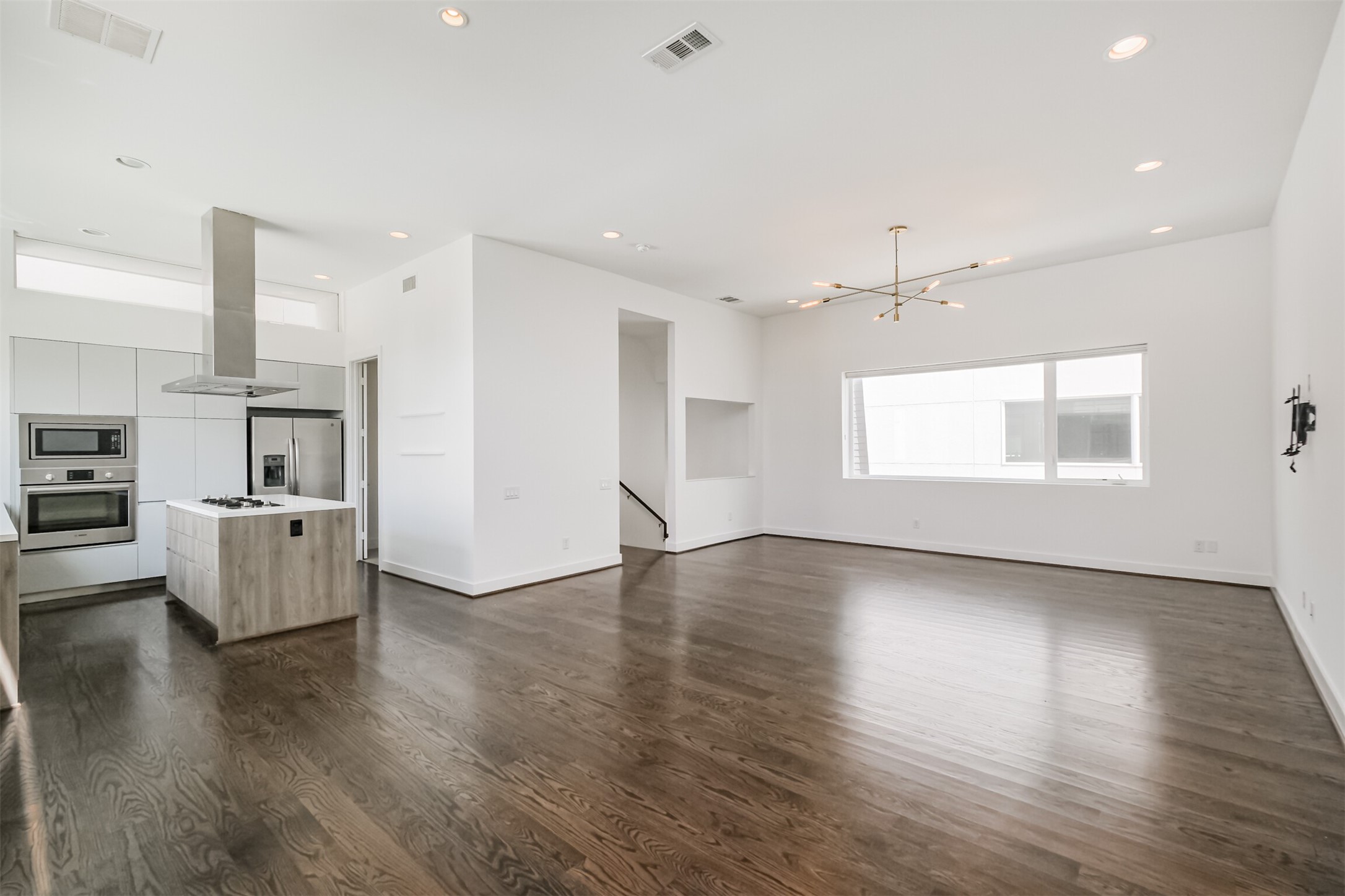 1157 West 18th Street Houston, TX 77008 - Photo 21 of 41 a view of an empty room with wooden floor and a kitchen