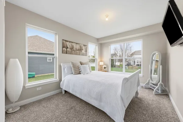 a spacious bedroom with a large bed and a chandelier