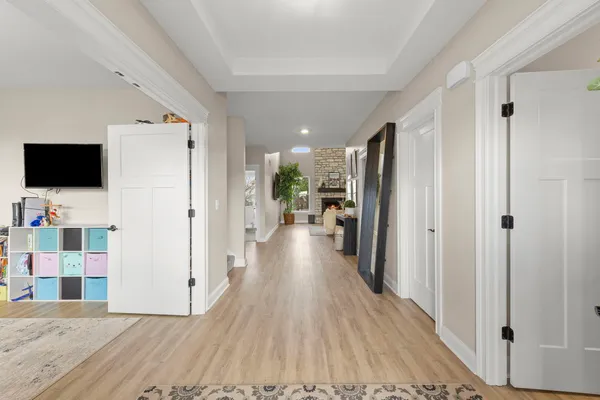 a view of a hallway with wooden floor and a living room