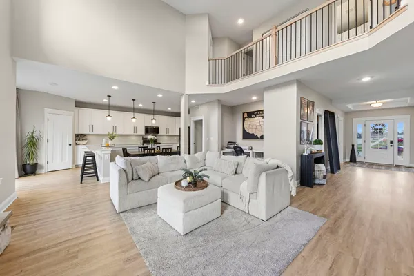 a kitchen with stainless steel appliances kitchen island granite countertop a dining table chairs refrigerator and cabinets