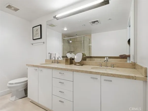 a bathroom with a granite countertop sink mirror and toilet