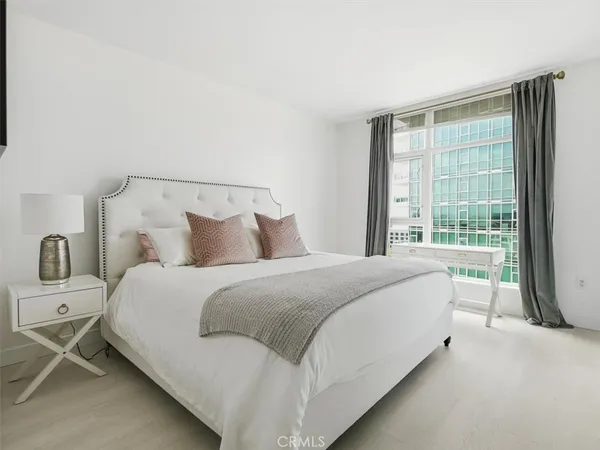 a large bed sitting in a bedroom next to a window
