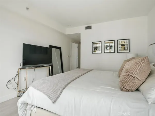 a bedroom with a bed and a flat screen tv