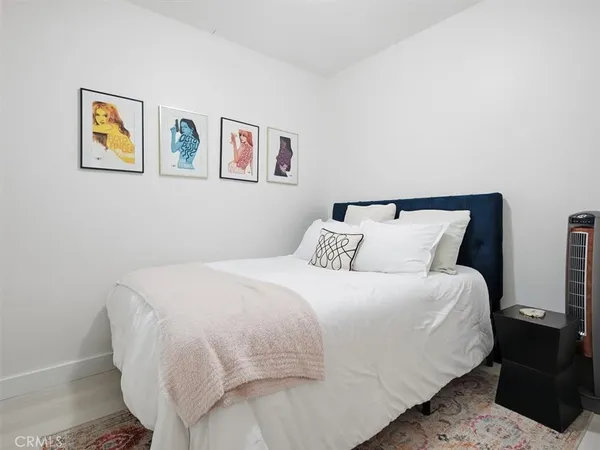 a bedroom with a bed and painting on the wall
