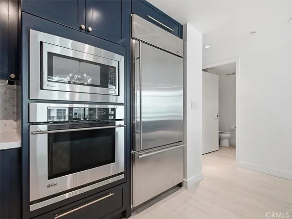 a kitchen with granite countertop stainless steel appliances and wooden floor