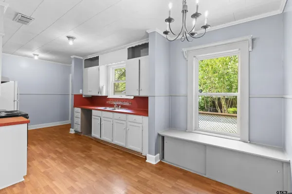 a kitchen with granite countertop a sink cabinets stainless steel appliances and a large window