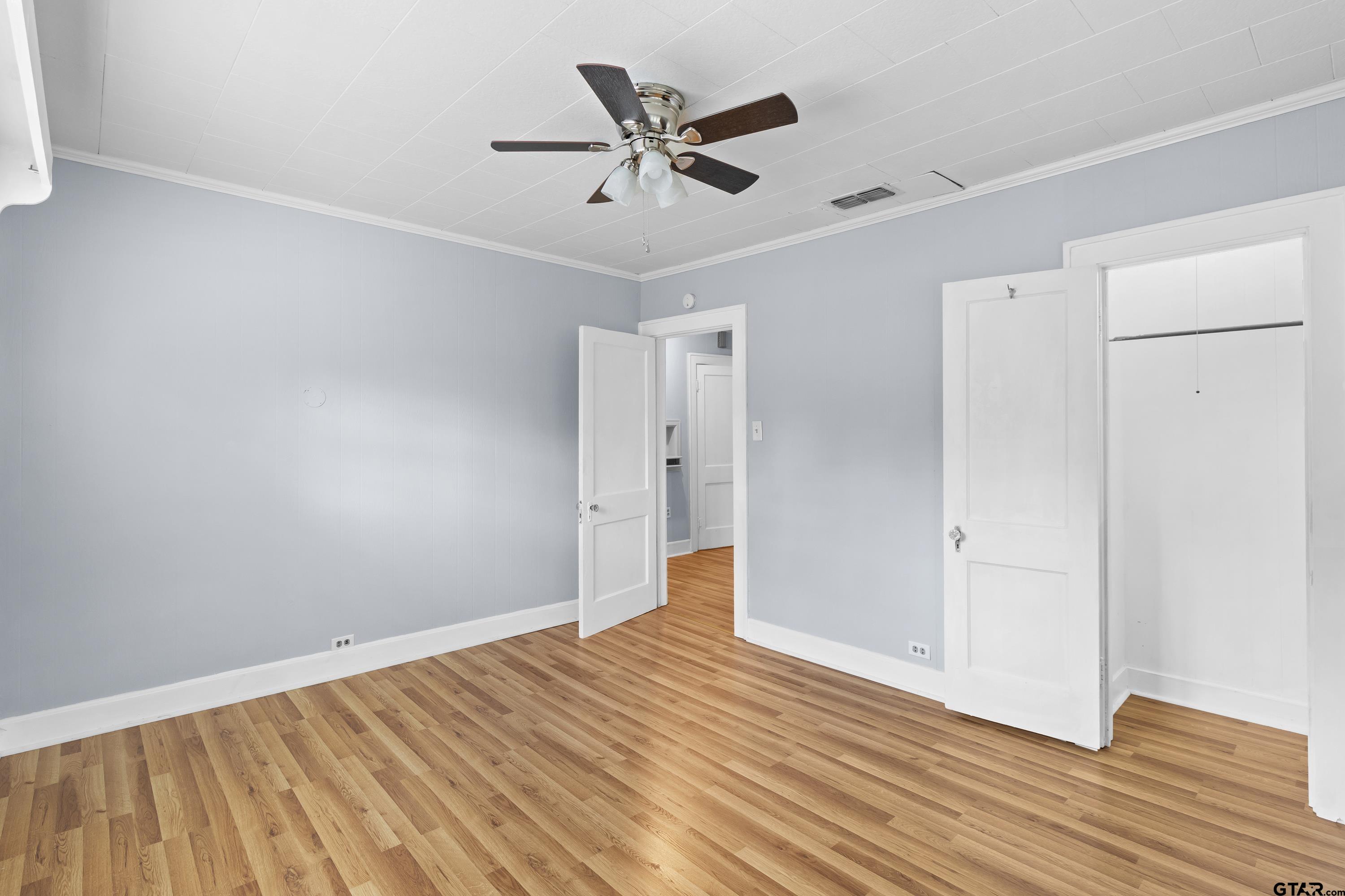 514 West Main Street Henderson, TX 75652 - Photo 19 of 35 an empty room with wooden floor and a ceiling fan