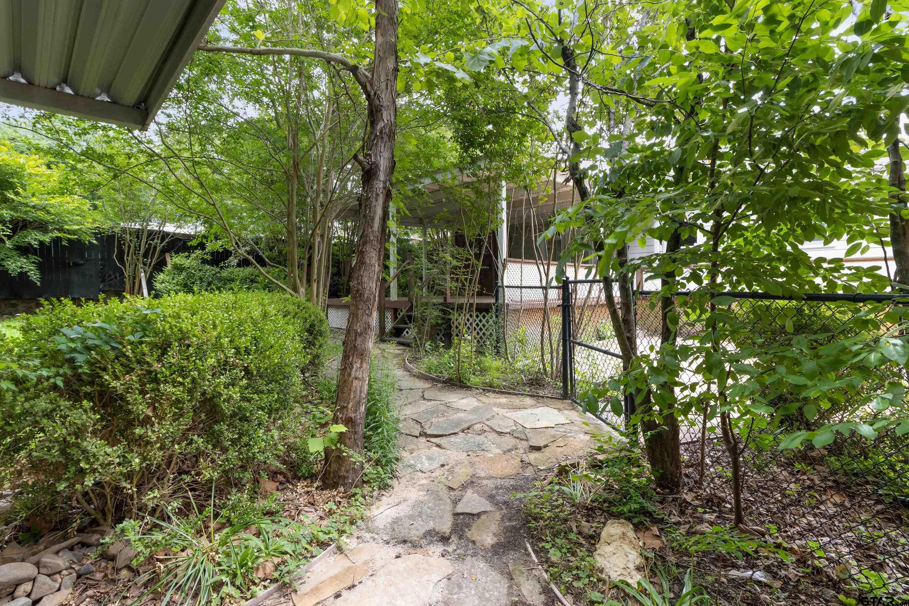 514 West Main Street Henderson, TX 75652 - Photo 30 of 35 a view of a yard with plants and large trees