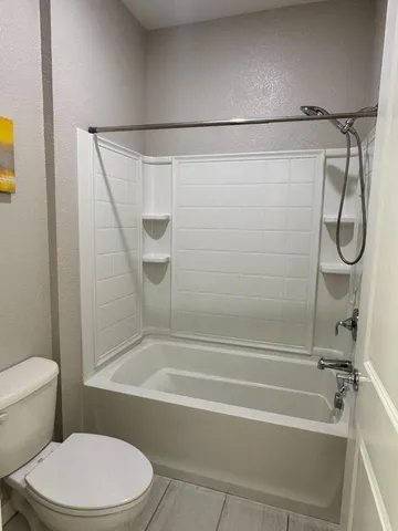 a bathroom with a toilet and a shower