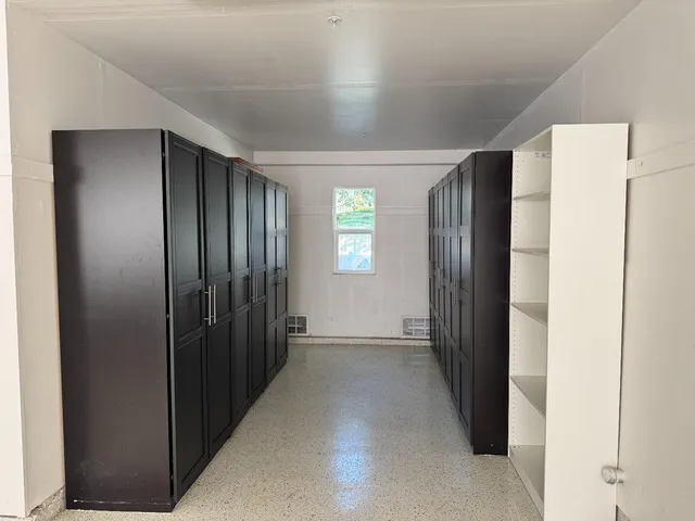 a view of a hallway with wooden shelves