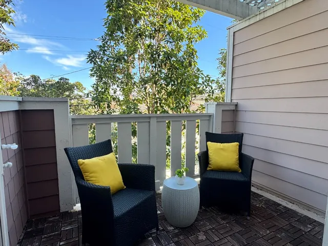 a view of a chairs and table in the back yard of the house
