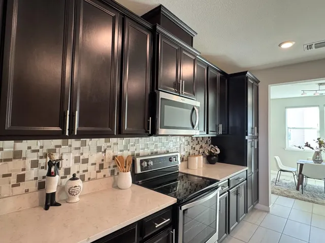 a kitchen with a sink refrigerator and cabinets
