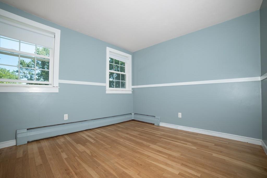46 Dover Road Millis, MA 02054 - Photo 10 of 28 an empty room with wooden floor and windows