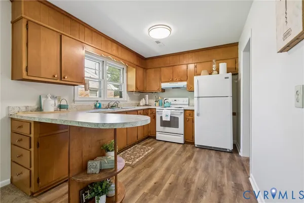 a kitchen with kitchen island a sink a stove and a refrigerator
