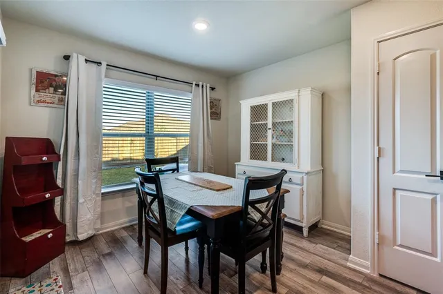 a kitchen with stainless steel appliances granite countertop a refrigerator a stove top oven a sink dishwasher and couches with wooden floor