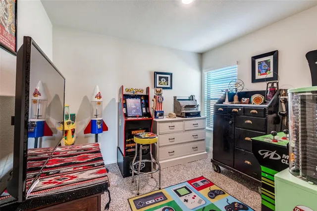 a living room with stainless steel appliances furniture a flat screen tv and kitchen view