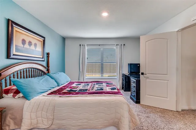 a bedroom with a bed and a lamp on dresser