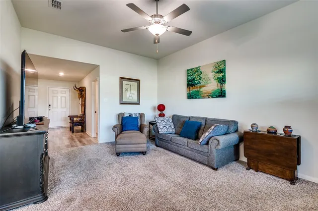 a living room with furniture a chandelier and a flat screen tv
