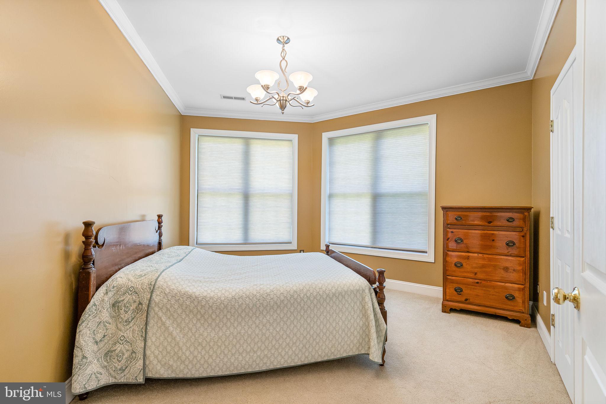 895 Stefaniga Road Stafford, VA 22556 - Photo 30 of 41 a spacious bedroom with a bed and a chandelier